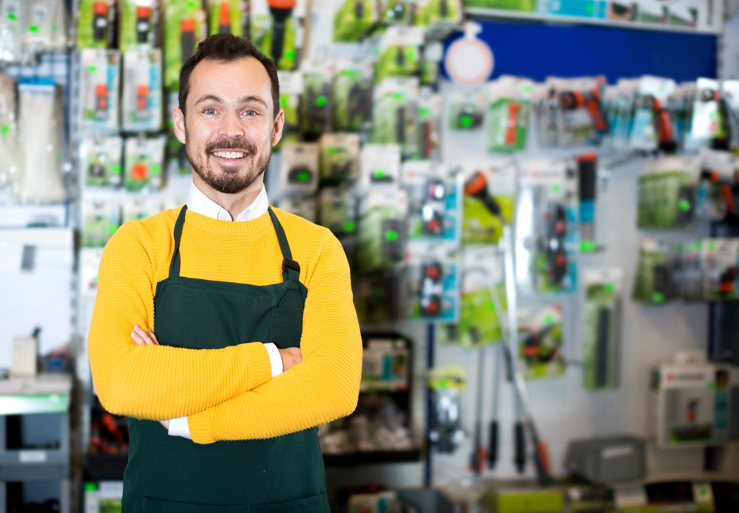Seller displaying various items in garden equipment shop