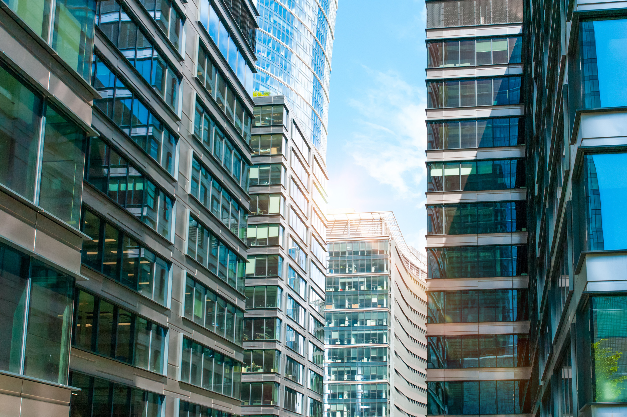 Stylish buildings with many windows under cloudy sky