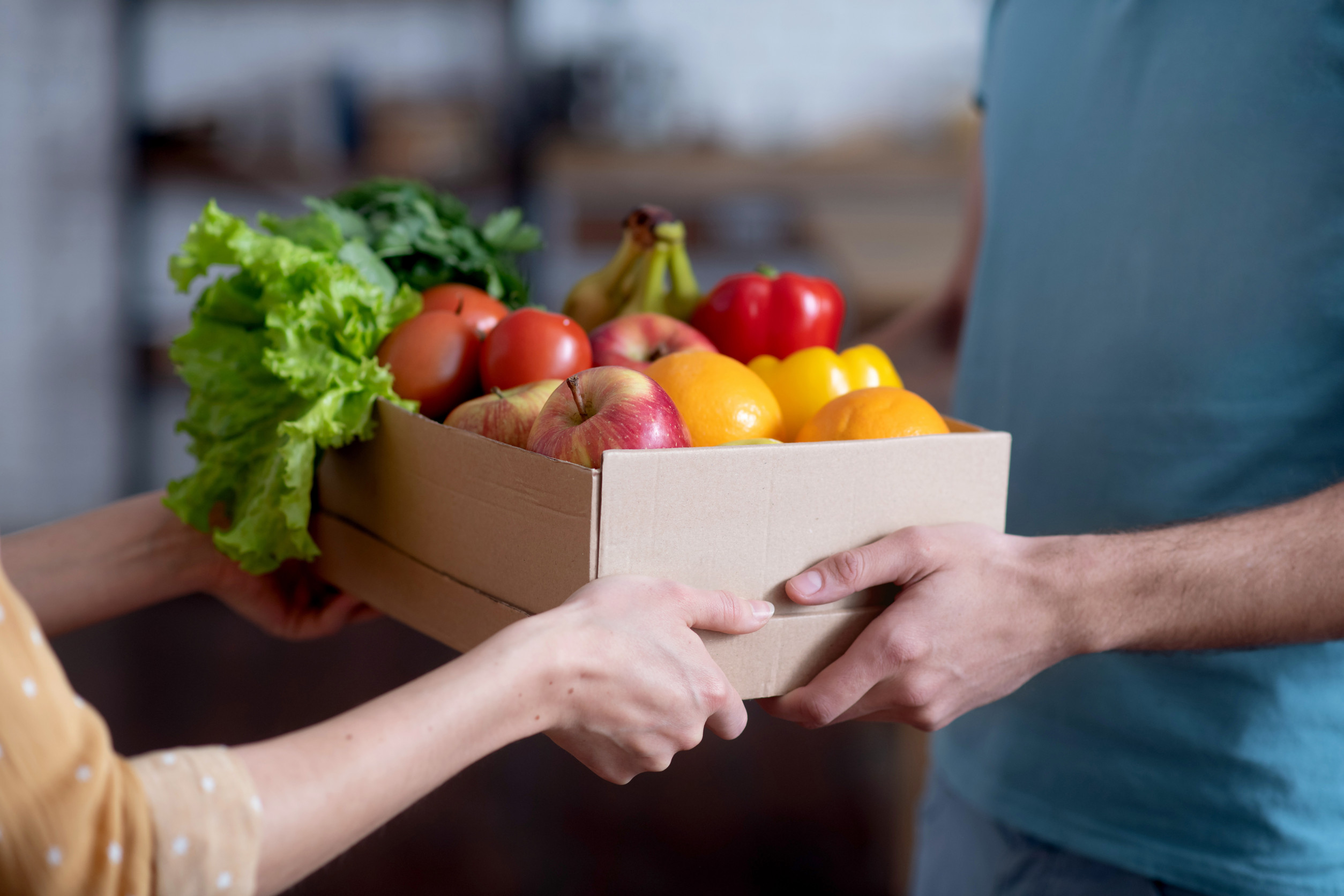 Close up picture of the courrier giving the groceries to the customer