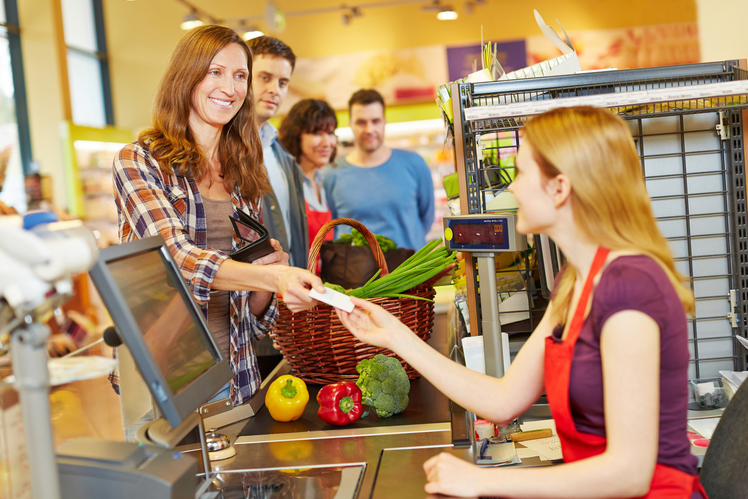 Woman paying with EC card at supermarket checkout